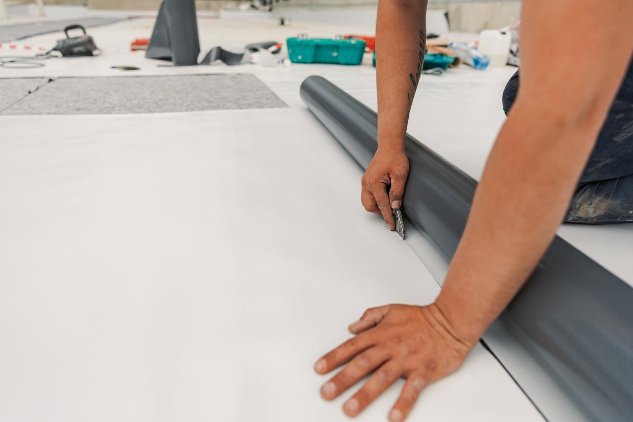 Worker specialized in mounting PVC membranes on a commercial roof